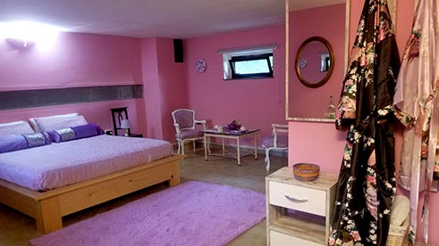 stanza lilla con letto e tappeto
